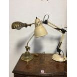 A brass desk lamp with shell cast shade on loop arm above a circular fluted base; and an
