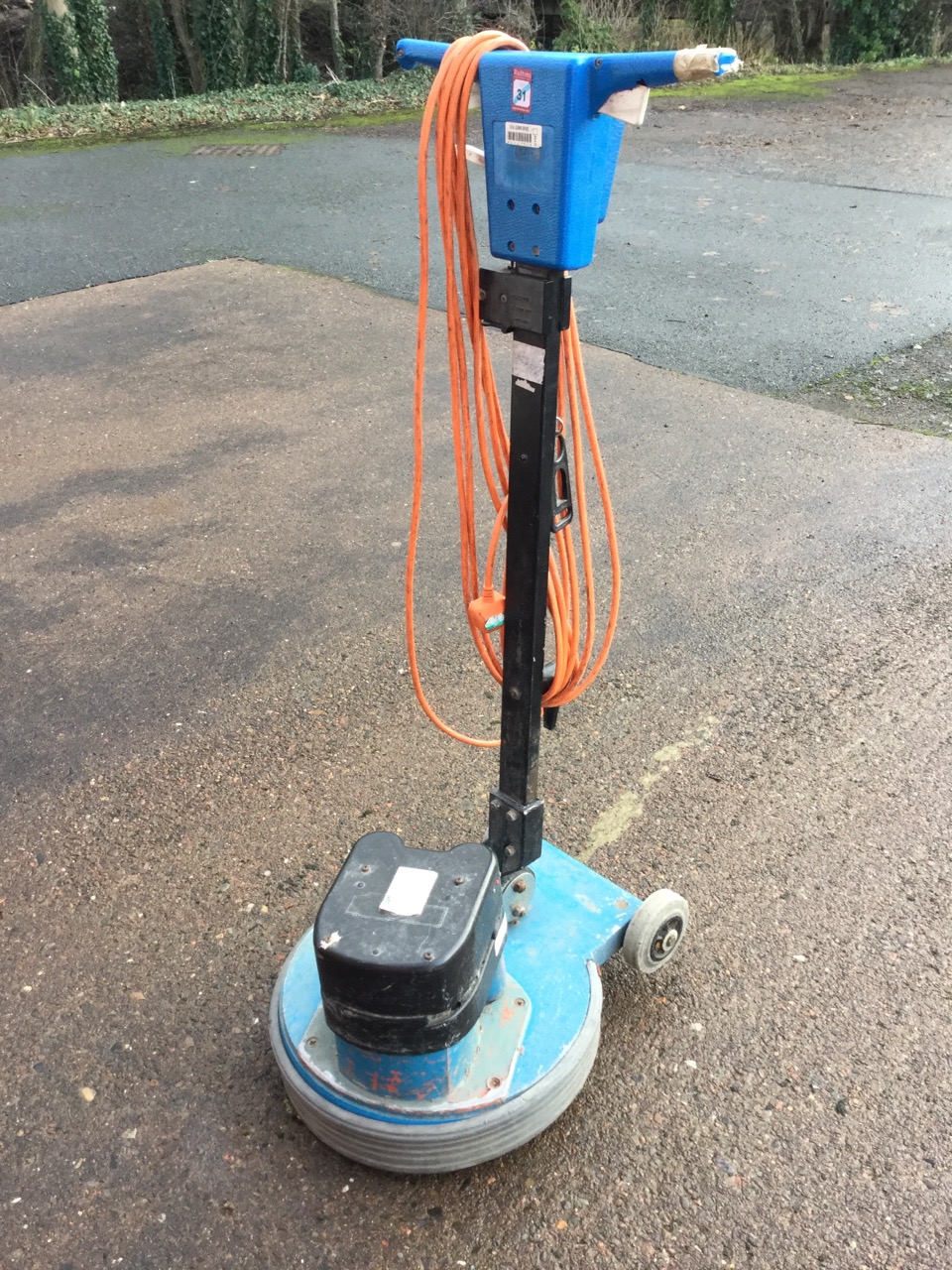 An electric floor polisher with long power cable.