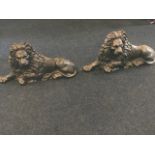 A pair of Victorian cast iron lion flatbacks, the beasts modelled as lions couchant with flowing