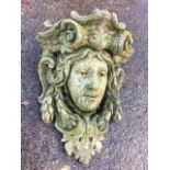 A composition stone wall pocket cast as a classical medusa head with scrolling. (17in)
