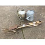 Two garden forks, a pruning saw and a spade; together with two tubular galvanised watering cans with