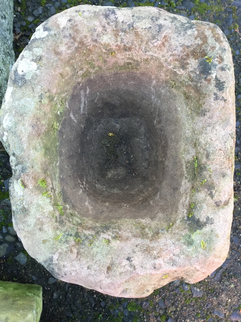 An ancient red sandstone quern. (18.5in x 15in)