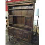 A George VI oak dresser, the delft rack with moulded cornice above open shelves and two cupboards