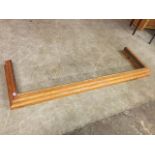 A pitch pine fender, the moulded curb with brass lining and rail. (66in x 20.25in ext)