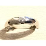 A 9ct gold diamond ring, the single circular diamond channel set within a rounded hallmarked band.