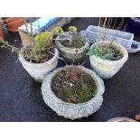 A set of three composition stone garden pots moulded with fluted floral panels beneath bulbous rims;