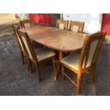 A pine dining table and chair set, the table with moulded top and spare leaf on turned columns,