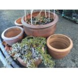 A set of four stoneware garden pots with moulded rims, and a larger matching example, all with