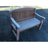 A 4ft garden bench with arched slatted back having rounded platform arms above a slatted seat,