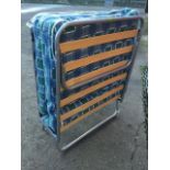 A folding camp bed with tubular frame and slatted base, complete with tartan mattress.