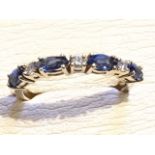 A 9ct gold sapphire half eternity ring, the marquise cut bezel set sapphires in channel with