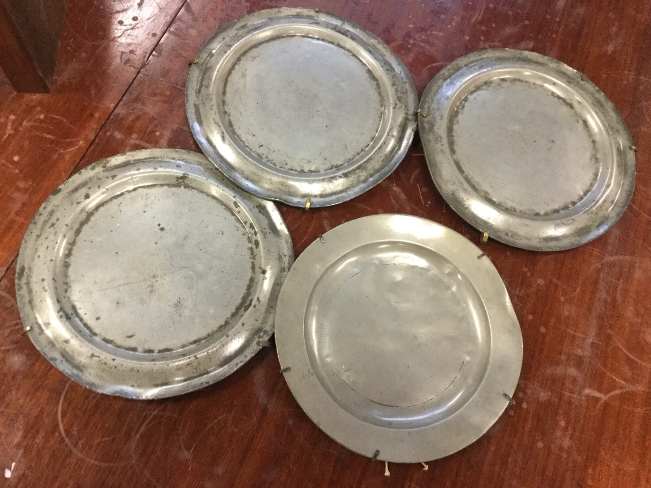 A set of three London hallmarked eighteenth century pewter plates; and another similar with London