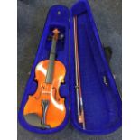 A hard cased violin complete with bow - looks unused.