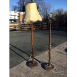 An oak standard lamp with turned column on circular moulded base, mounted with fawn panelled