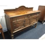 An Edwardian oak sideboard with arched upstand on rectangular moulded top above two frieze drawers