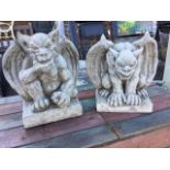 A pair of composition stone gryphons, the winged clawed beasts on rectangular plinths. (11.75in) (