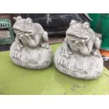 A pair of composition stone frogs, the beasts modelled on boulders incised Welcome. (7.5in) (2)