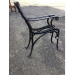 A pair of cast iron bench ends with scrolled arms on sabre legs - no slats. (31in) (2)