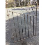 A wrought iron garden gate, the rounded frame with vertical bars beneath a scrolled panel. (32in x