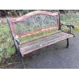 A rectangular garden bench, the arched back panel cast with sunflowers above a slatted seat, with