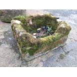A rectangular stone trough having one long curved side - A/F. (20in x 15.5in x 11in)