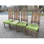 A set of four Jacobean style European oak dining chairs, the carved backs with pierced scrolled