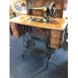 A Victorian oak cased Singer sewing machine, the moulded table with two small drawers on pierced