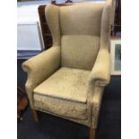 A Georgian style oak Mollis Marshall wing armchair, having padded back above shaped arms and