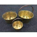 A Victorian brass jam pan with copper riveted channelled iron handle; another brass jam pan with