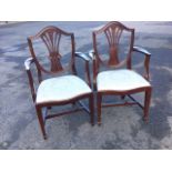 A pair of Hepplewhite style mahogany elbow chairs, the shield shaped moulded backs framing pierced