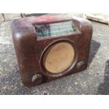 A Bush brown bakelite cased valve radio, with angled glass dial above circular speaker - working. (