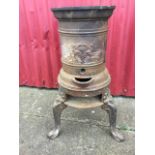 A tubular French cast iron pot stove on three scrolled legs. (20.5in)