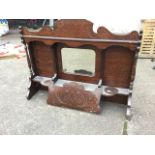 A walnut organ back with scrolled carved decoration, having central bevelled mirror above shelf