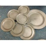 A married set of six eighteenth century pewter plates with folded rims - 9in; and a 14.5in antique