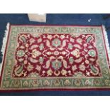 An oriental style wool rug, the maroon field woven with linked foliage framed by green frieze with