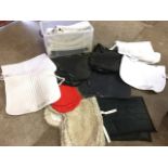 A large quantity of white and coloured numnahs and saddle pads/blankets - lambskin, fleece,