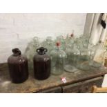 Sixteen glass demijohns, the jars each with twin lug handles to concave necks - two brown. (16)