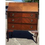 A mahogany bureau with quarter-veneered fallfront revealing a fitted interior with compartments