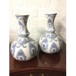 A pair of blue & white decorative vases with waisted necks above bun shaped bodies, decorated with