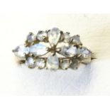 A 9ct gold opal moonstone ring, the stones set in the form of a pierced oval flowerhead panel, on