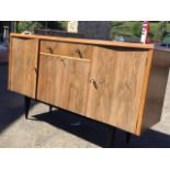 A 5ft 70s rectangular walnut sideboard, with pair of concave cupboard doors framing a drawer and