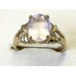 A 9ct gold rose quartz ring, the oval claw set stone raised above pierced bow type ribs, mounted