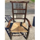 A C19th country oak and elm Lancashire style armchair with spindle back above a rush seat, the