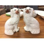 A pair of Victorian Staffordshire wally dogs decorated with pink noses and yellow eyes, having
