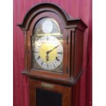A 1930s mahogany grandmother clock with arched hood enclosing a brass dial with silvered chapter