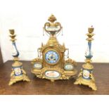 A French Sevres porcelain mounted ormolu garniture, the clock surmounted by an urn with flowers,