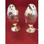 A pair of silver plated egg cups or egg warmers, modelled as chicks, the covers with glass eyes on