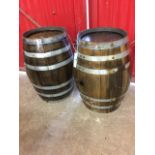 A pair of oak barrels, the staves bound by six riveted metal strap bands. (22.5in x 12.5in) (2)