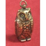 A novelty brass sovereign case modelled as an owl with glass eyes, the interior with twin circular