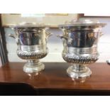 A pair of silver plated wine coolers of urn shape with bead cast rims and acanthus moulded